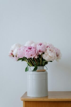 A delicate arrangement of pink peonies in a stylish vase, perfect for interior decoration.
